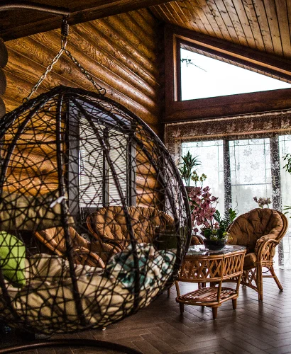 Деревянный дом из бревен с пластиковыми треугольными окнами ламинированными под дерево.